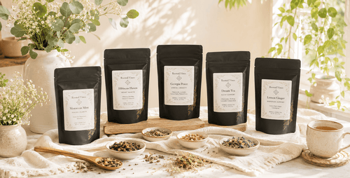 Packages of tea sitting on a wooden table with light from a window shining on them