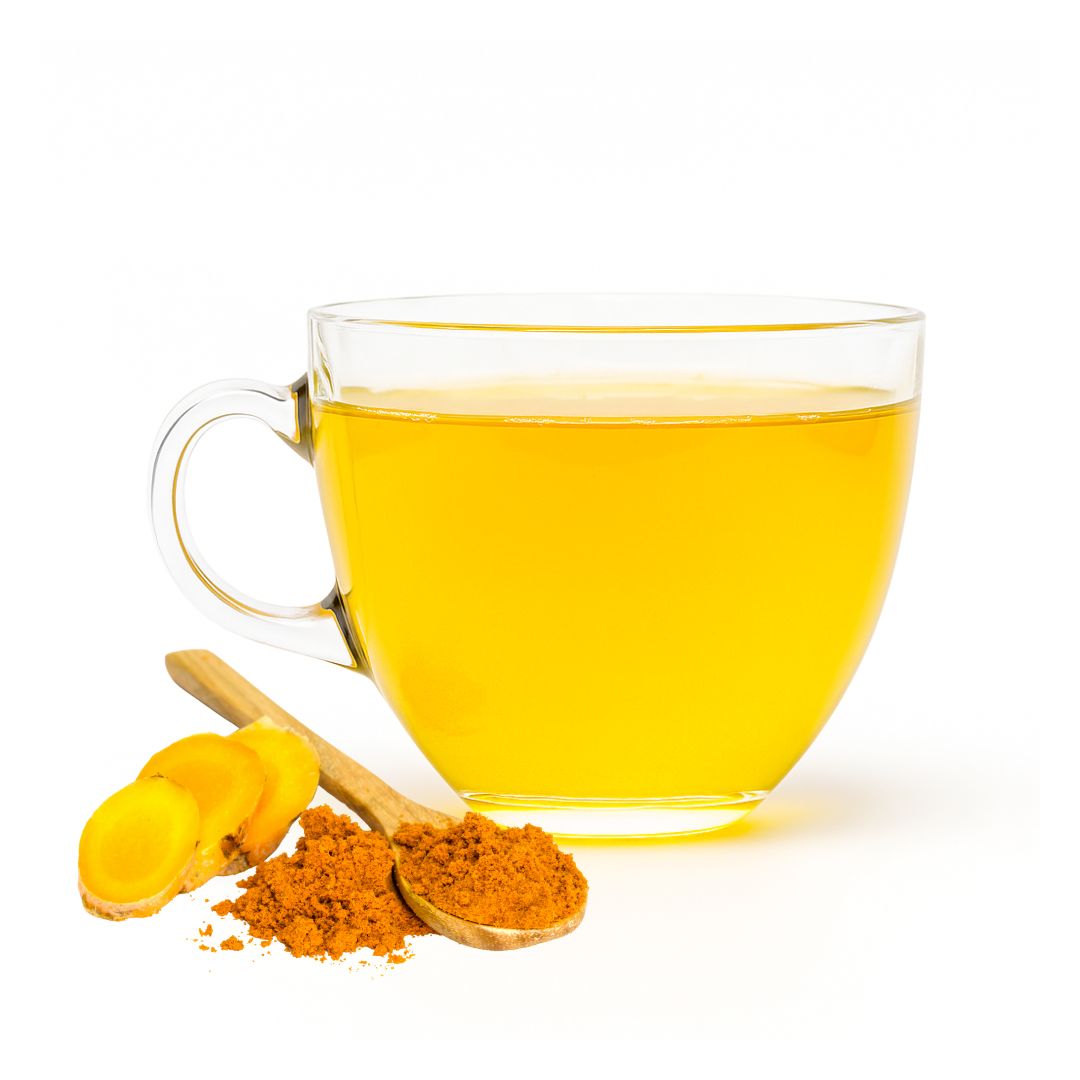 Clear glass mug filled with yellow turmeric tea, accompanied by turmeric roots and powder on a white background.