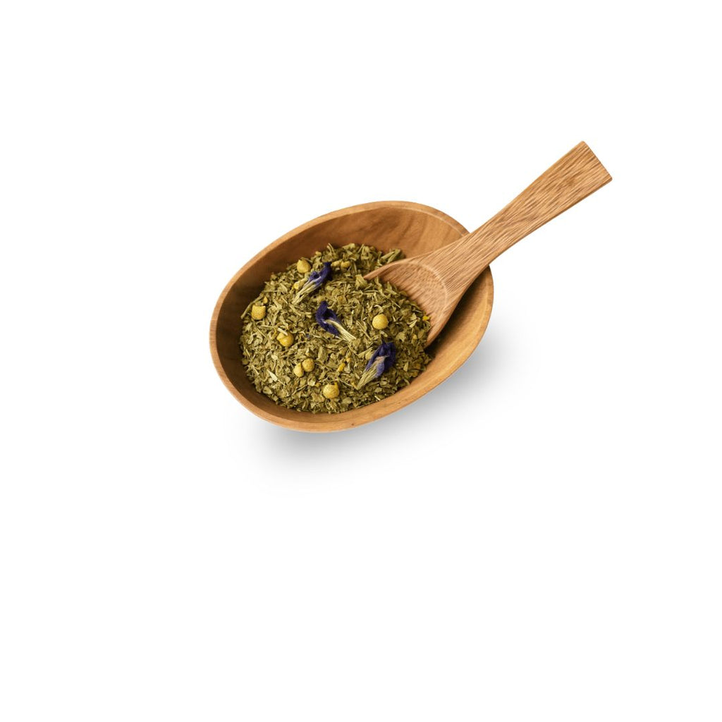 Wooden bowl with green herbal tea and a wooden spoon on a white background