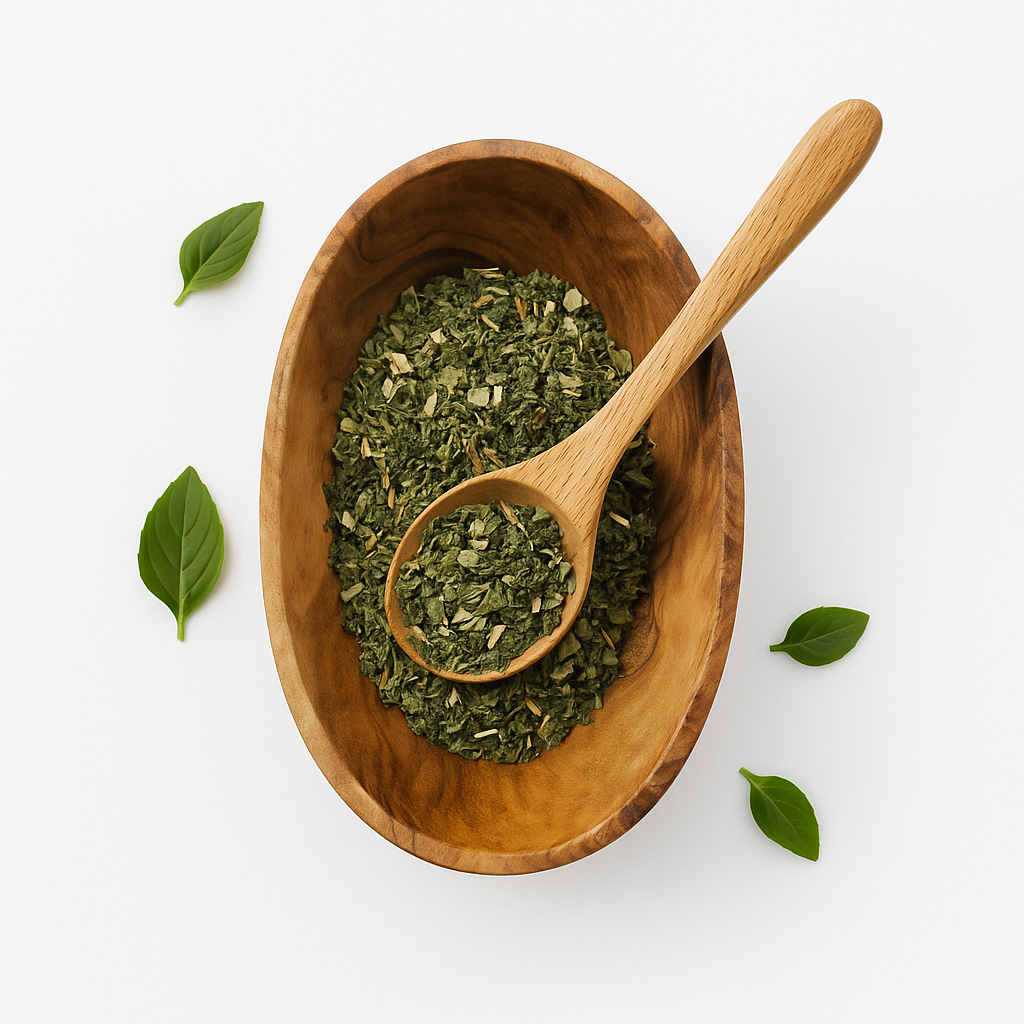 Wooden bowl filled with dried green herbs and a wooden spoon on a white background