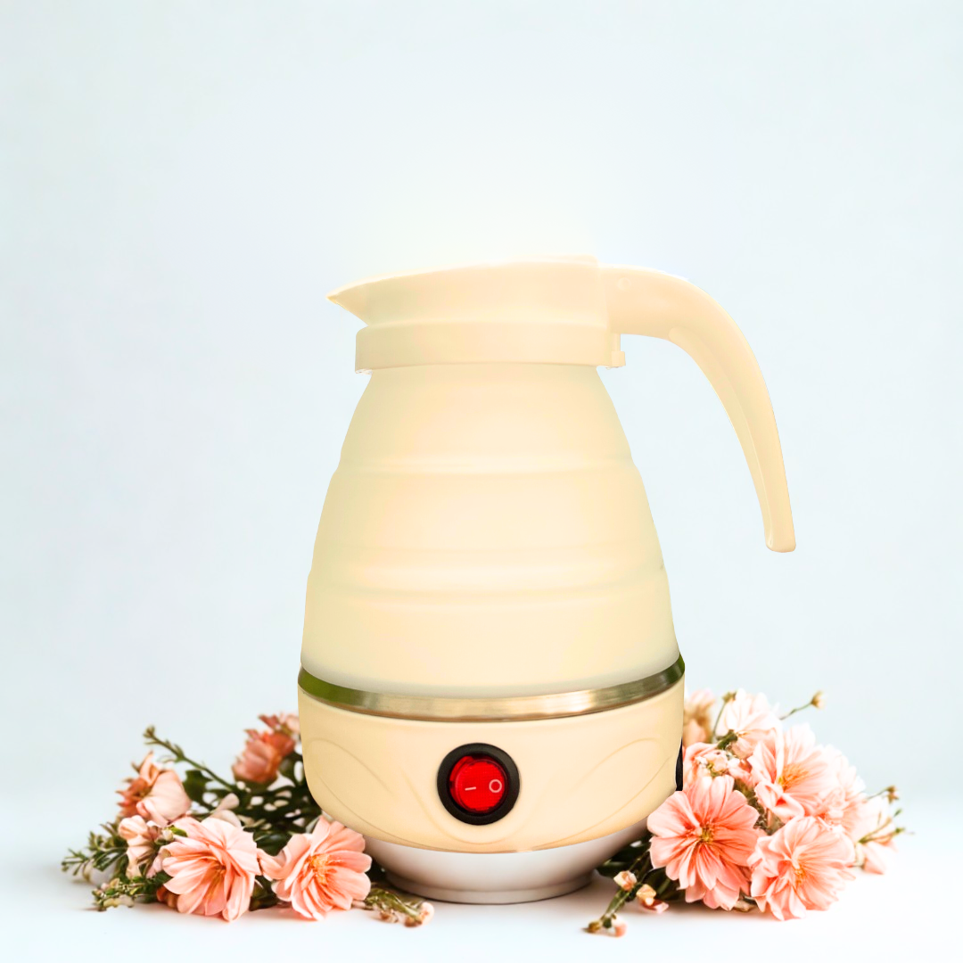 Beige electric kettle with a red light on a white background with pink flowers.
