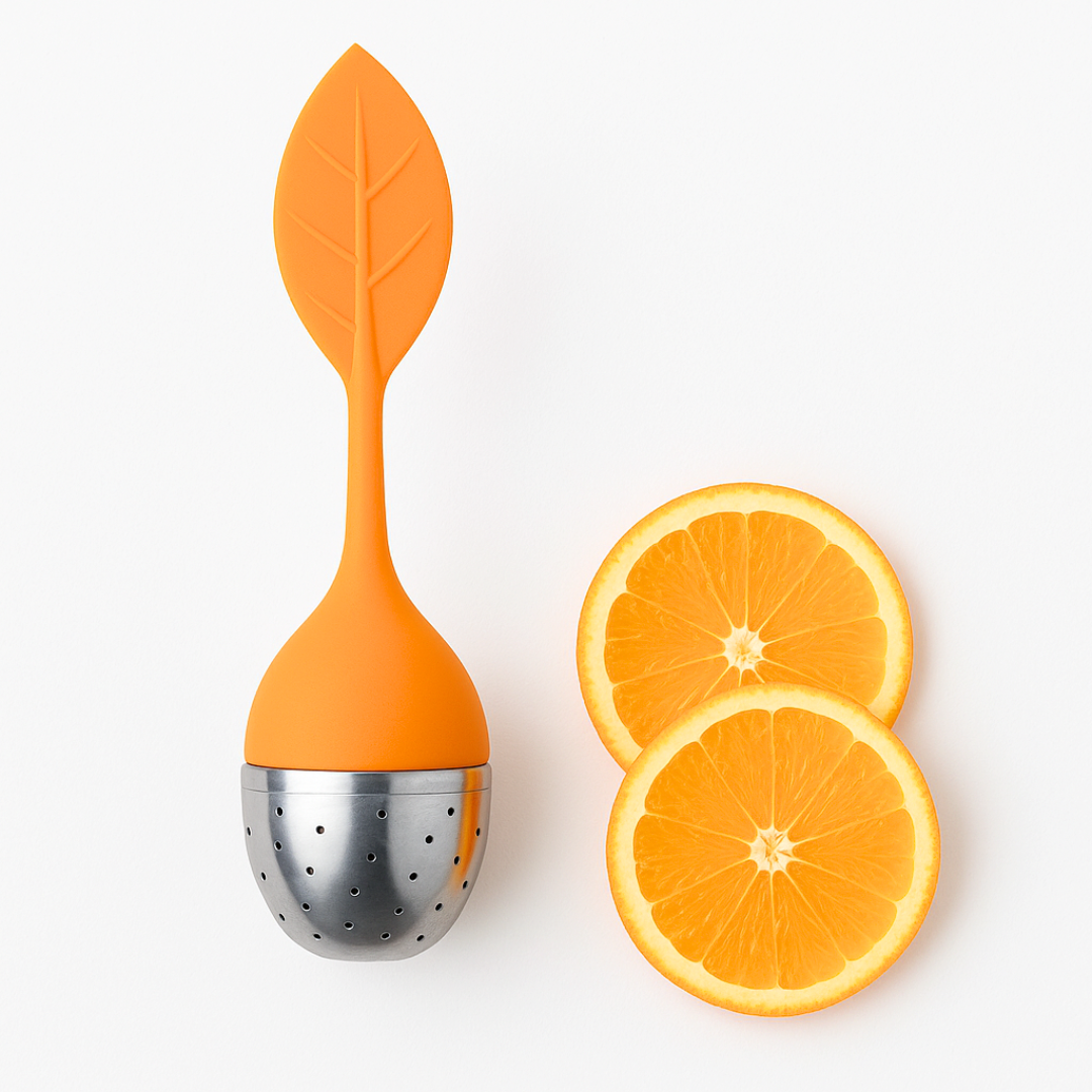 Orange tea infuser with a silver base next to two slices of orange on a white background