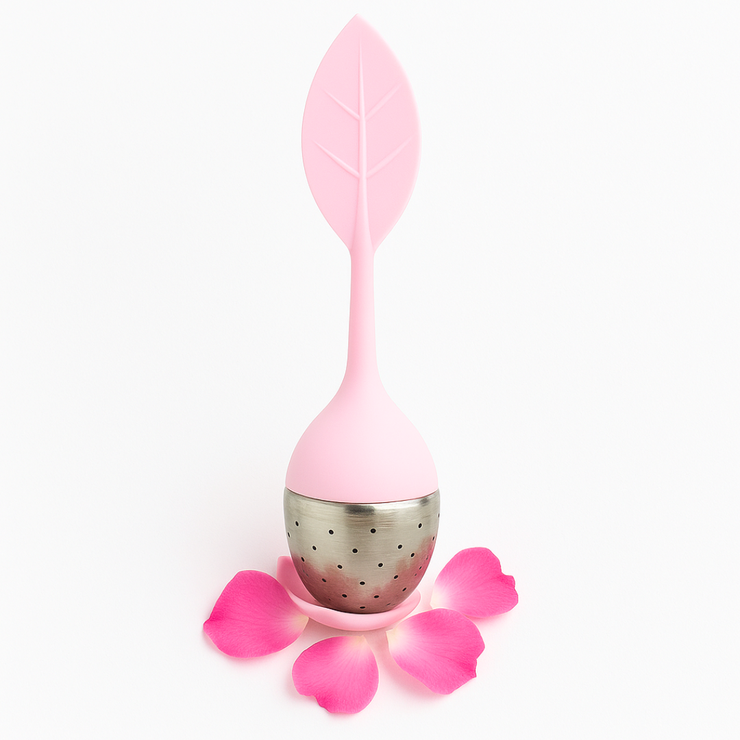 Pink tea infuser with leaf design on a white background