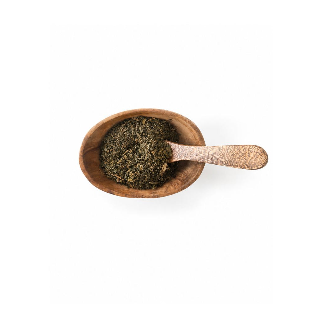 Raspberry leafs in a brown wooden bowl with a wooden spoon. Upclose look. 