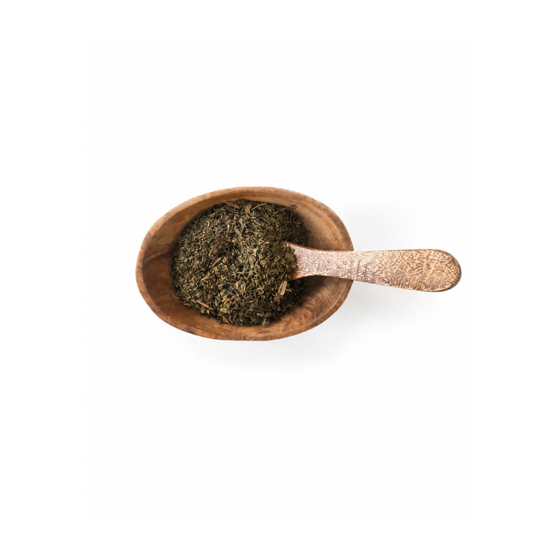 Raspberry leafs in a brown wooden bowl with a wooden spoon. Upclose look. 