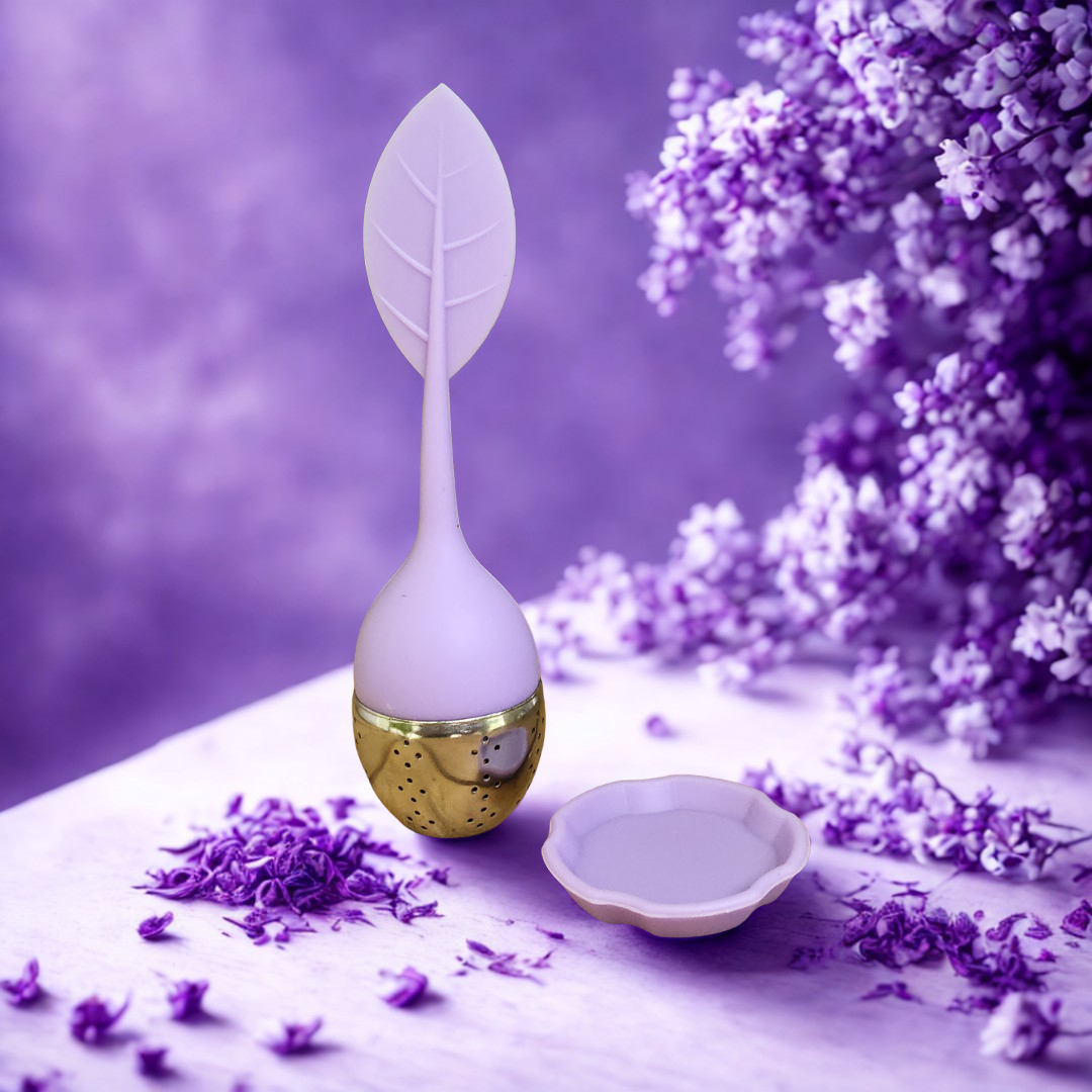 Tea infuser with leaf design on a purple background with lavender flowers