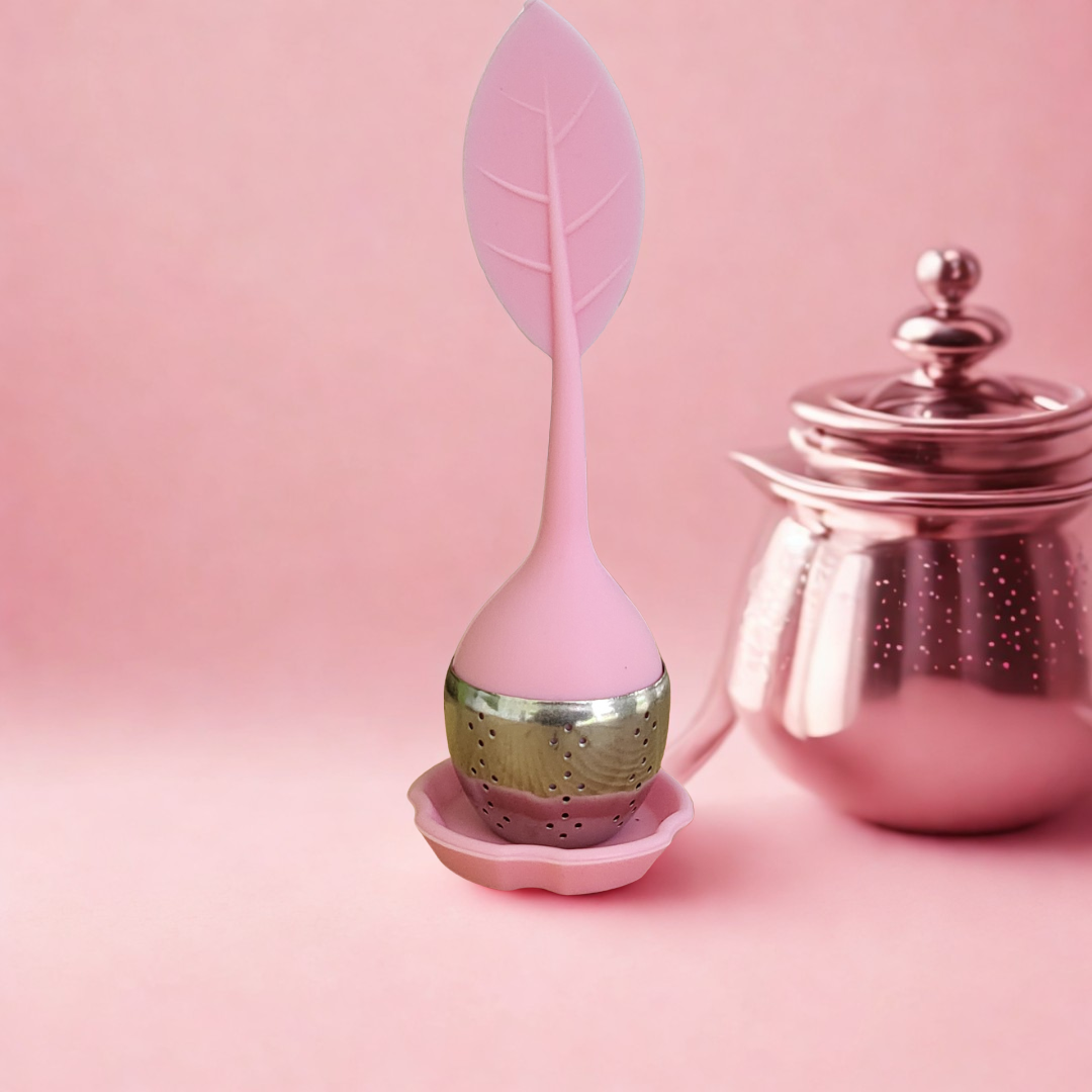 Pink tea infuser with leaf design on a pink background