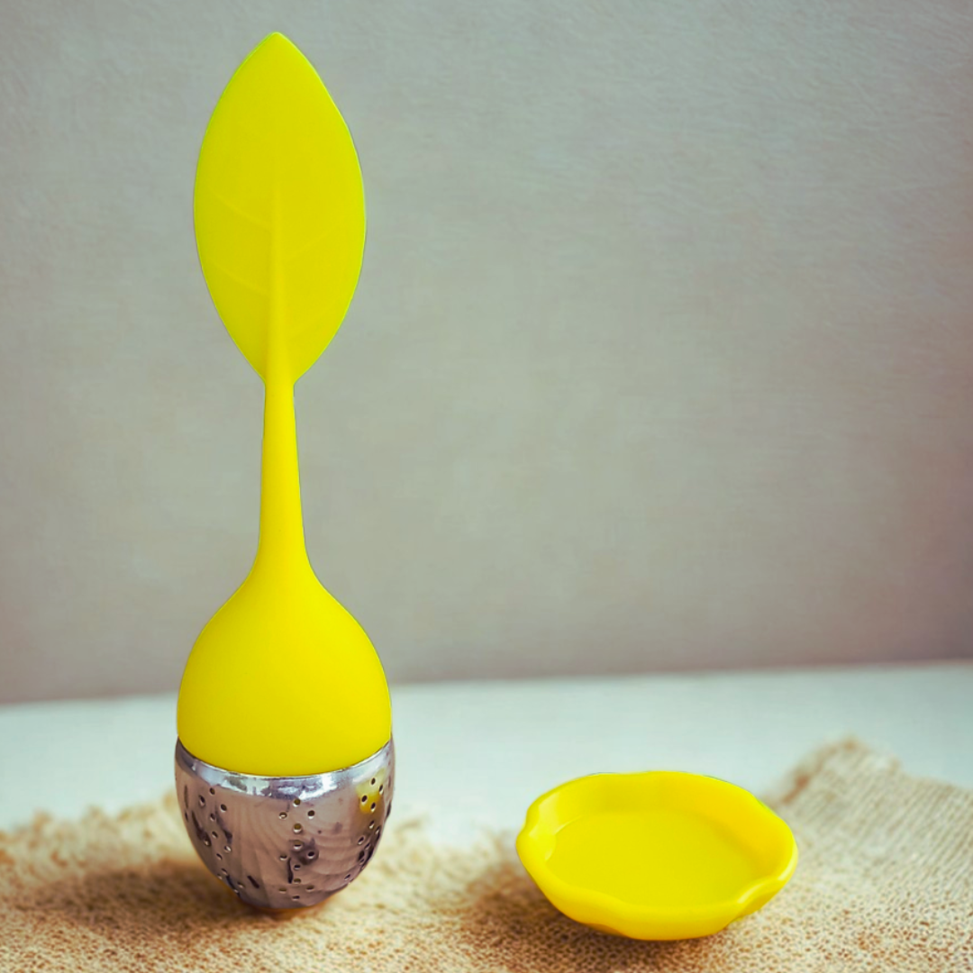Yellow silicone tea infuser on a textured surface with a neutral background