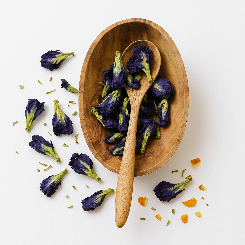 Wooden bowl and spoon filled with dried butterfly pea flowers on a white background