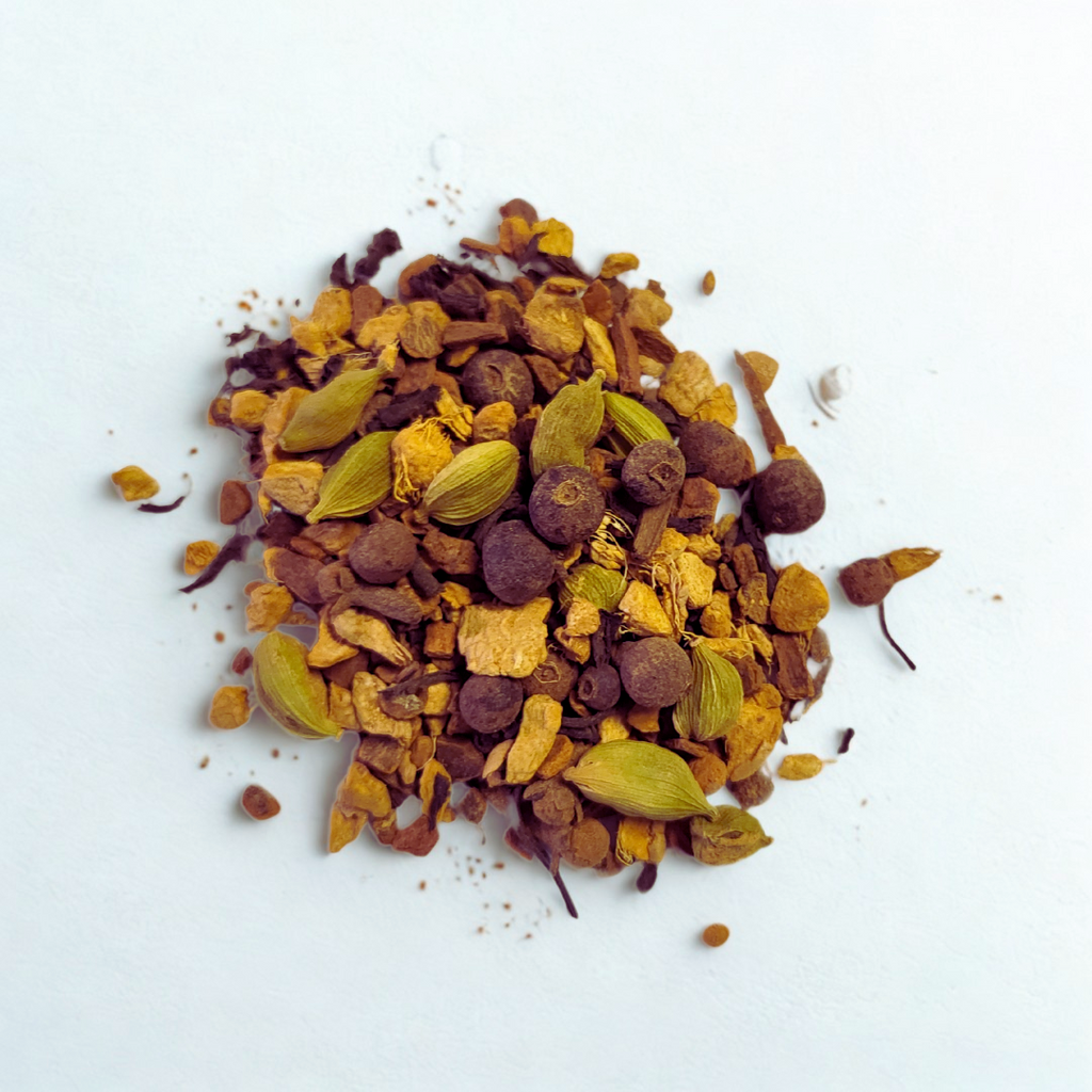 Spices including cardamom pods, cinnamon sticks, and other dried herbs on a white background