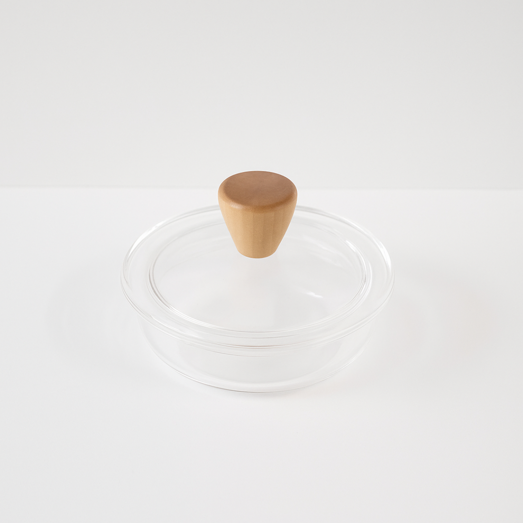 Clear glass lid with a wooden knob on a white background