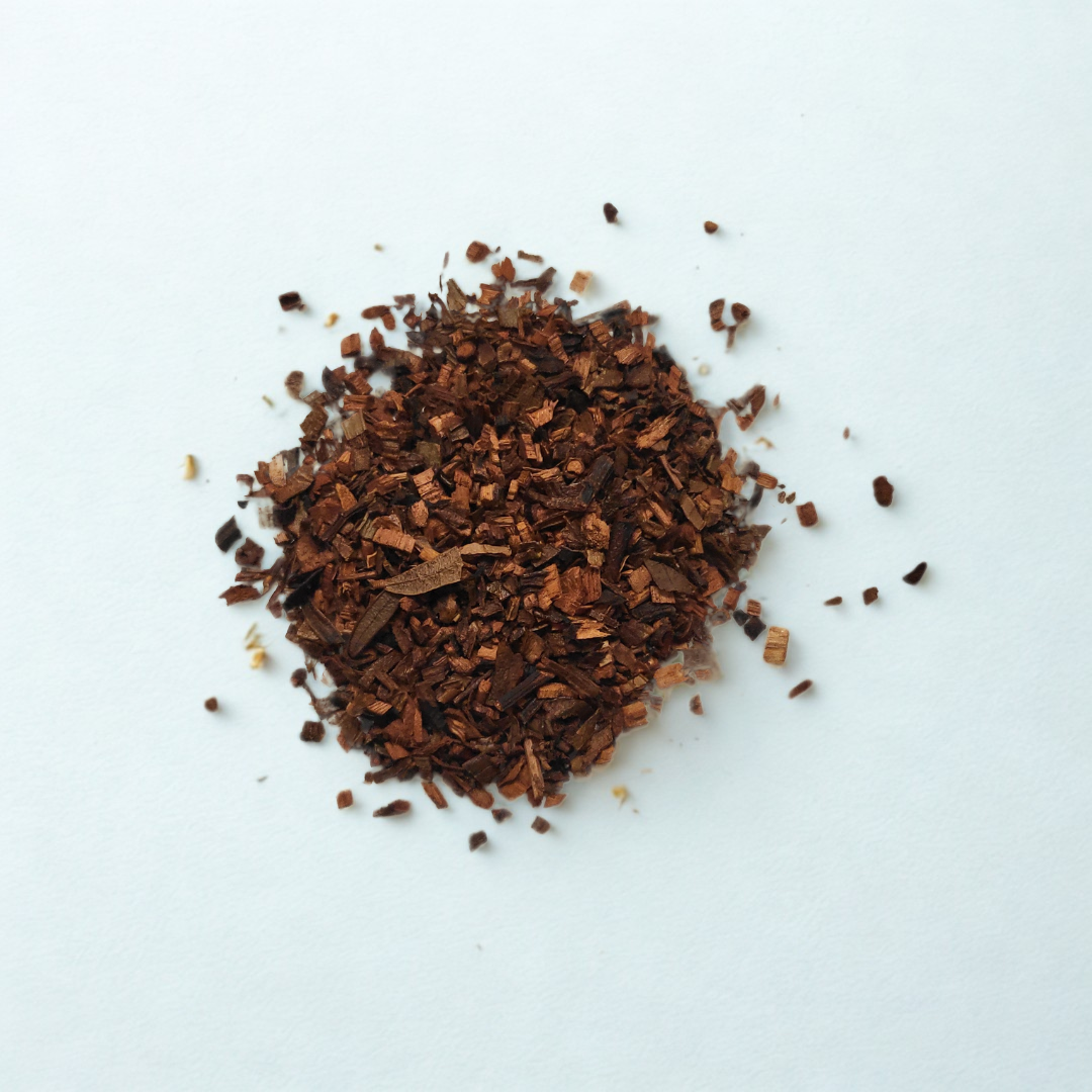 Dried brown herbs or spices on a white background